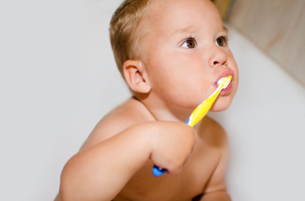 Kleiner Junge bei der ersten Zahnpflege - Schlechten Zähnen mit dem Kinderuntersuchungsheft vorbeugen